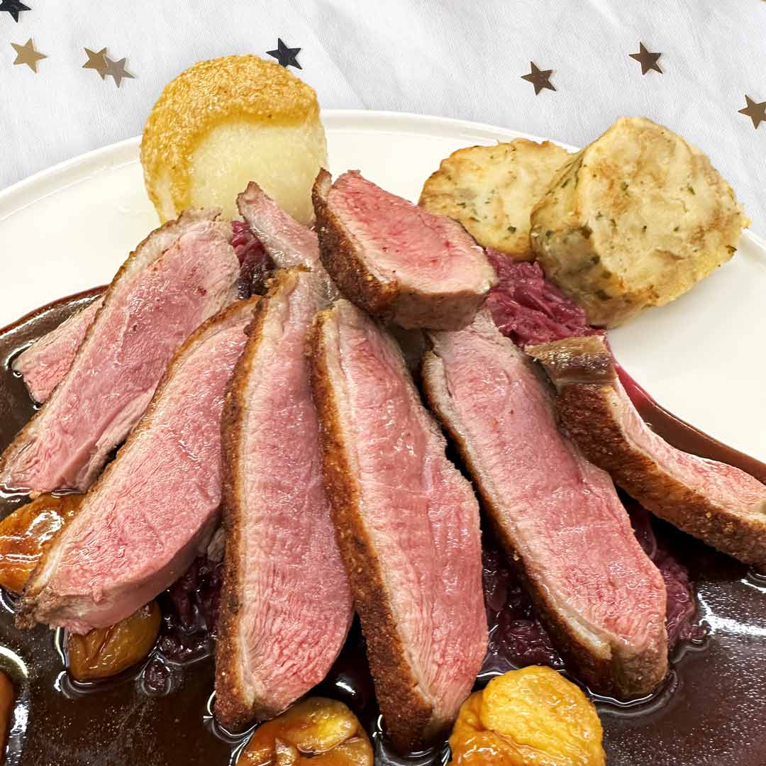 Barbarie-Entenbrust rosa gebraten mit Rotweinsoße, Apfel-Rotkraut, glasierte Maronen, Kartoffel- & Serviettenknödel